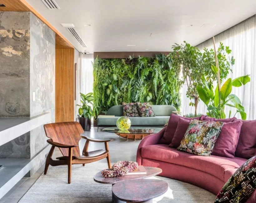 Sala de estar moderna com parede verde vertical exuberante, sofá roxo e móveis de madeira.